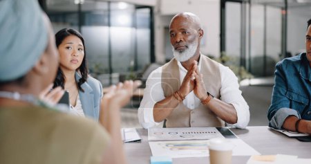 Photo for Senior black man, boss or meeting with business people in collaboration for project planning in office. Team discussion, employees or African CEO with paperwork listening to ideas or feedback review. - Royalty Free Image