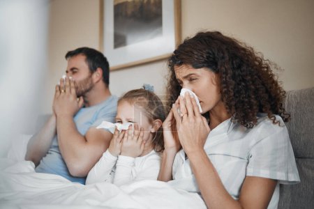 Parents, girl and bed with tissue, blowing nose and sick together with allergies, flu or covid in house. Father, mother and daughter with toilet paper, cleaning and hygiene for sneeze in family home.