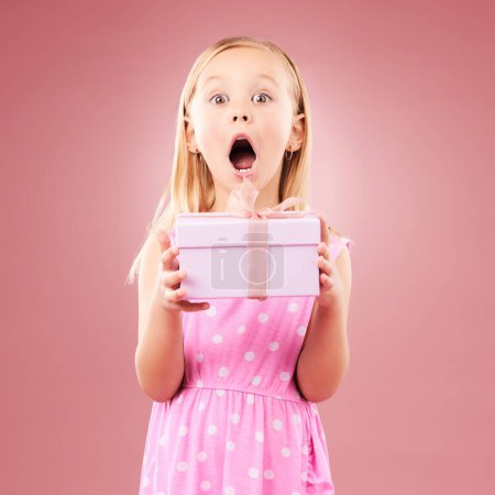 Photo for Present, gift and wow portrait of a child in studio for birthday, holiday or happy celebration. Excited girl on a pink background with ribbon, mouth open and amazing surprise giveaway prize in box. - Royalty Free Image