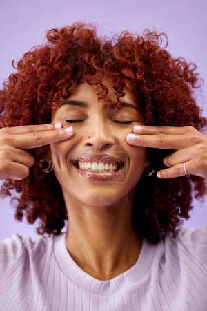 Photo for Happy, hair and woman hands on face in studio for natural, cosmetic or wellness on purple background. Haircare, beauty and lady model smile for red afro growth, texture or dye satisfaction results. - Royalty Free Image