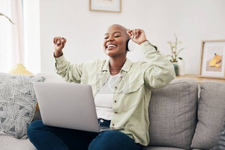 Photo for Music, headphones and black woman with laptop on sofa dance, happy and free in her home. Radio, earphones and African female dancing to online feel good podcast in living room smile for subscription. - Royalty Free Image