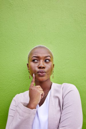 Denk, Idee und junge schwarze Frau an einer grünen Wand mit trendigem, stilvollem und elegantem Outfit für Mode. Träumerisches, achtsames und afrikanisches weibliches Modell mit positiver und selbstbewusster Haltung mit Attrappe