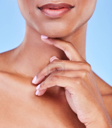 Photo for Hand, mouth and beauty with a woman closeup in studio on a blue background for natural skin wellness. Skincare, lips and finger of a model touching her face for an aesthetic manicure or cosmetics. - Royalty Free Image