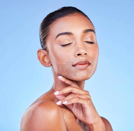 Photo for Beauty, cosmetics and skincare with face of woman in studio for health, dermatology and facial. Glow, self care and wellness with person on blue background for spa treatment, grooming and makeup. - Royalty Free Image