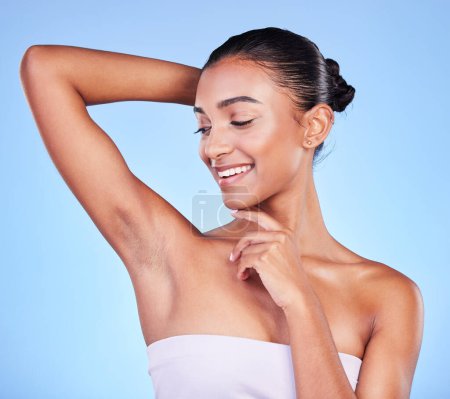 Photo for Body care, smile and woman in studio with armpit, cleaning and BO control on blue background. Smooth skin, hygiene and happy female model with laser, hair removal or underarm treatment satisfaction. - Royalty Free Image