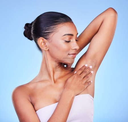 Photo for Woman, touching armpit and skincare with epilation and beauty, grooming and hygiene isolated on blue background. Hair removal, smooth skin and glow with dermatology, clean body and wellness in studio. - Royalty Free Image