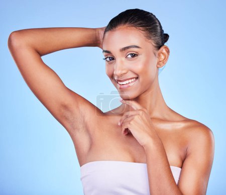 Photo for Armpit, epilation and woman in portrait with beauty, grooming and smile isolated on blue background. Hygiene, cleaning body and hair removal with skincare, cosmetics and dermatology in a studio. - Royalty Free Image
