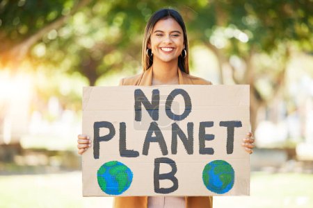 Photo for Woman, poster and climate change sign at park for earth, environment and green or eco friendly protest. Young person in portrait and nature, planet or globe support for sustainable world and action. - Royalty Free Image