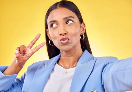 Photo for Business woman, peace sign and studio selfie with funny face, pouting and emoji by yellow background. Entrepreneur, hand and thinking with kiss, comic lips and icon for vote, social media or web blog. - Royalty Free Image