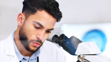 Téléchargez les photos : Laboratory scientist using microscope to examine monkeypox virus and note his discovery. Closeup of serious biochemist engineer doing medical research with scientific equipment for breakthrough cure. - en image libre de droit