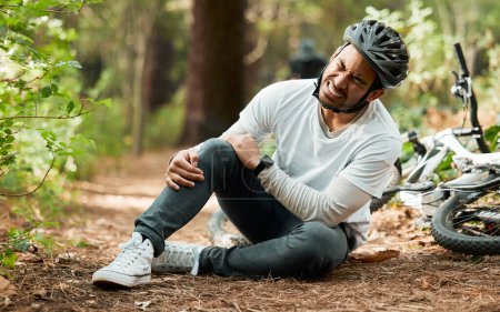 Photo for Man, knee pain and injury in forest with bike, stress and sitting on ground with emergency in nature. Cycling athlete, young guy and accident with bicycle, training and exercise with crash in woods. - Royalty Free Image