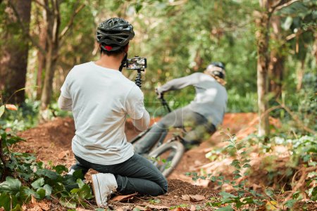 Photo for Man, bike and forest with photographer, speed and phone for race, cycling video or post on web blog. Guy, bicycle and recording for vlog, live streaming or social media in woods for outdoor sports. - Royalty Free Image