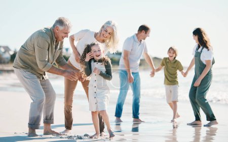 Téléchargez les photos : Grand-parents, enfants et grande famille avec jeu à la plage, rire comique ou coller pour l'amour, le soleil ou excité en vacances. Hommes, femmes et enfants par la mer, les vagues ou heureux pour des vacances d'été en Espagne. - en image libre de droit