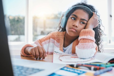 Photo for Child, headphones and girl tired of home school, e learning and future online education. Thinking, bored and kid with ADHD, autism and sad at laptop while drawing and listening to audio at table. - Royalty Free Image