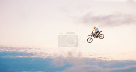 Photo for Motorcycle, sky background and competition for adventure, freedom and exercise with safety gear. Bike, jump and talent for training with fitness, balance or challenge in nature on mock up space. - Royalty Free Image
