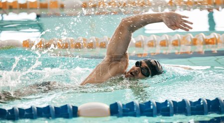 Fitness, Workout und ein Schwimmer in einem Pool während eines Rennens, Wettbewerbs oder Ausdauertrainings in einem Fitnessstudio. Bewegung, Wasser und Sport mit einem Athleten, der schwimmt, um Geschwindigkeit, Gesundheit oder Freistil-Leistung zu verbessern.