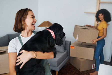 Photo for Dog, lesbian couple and new real estate, funny and bonding together in living room. Happy gay women with pet in house, apartment and moving in to property home, laughing and playing with animal. - Royalty Free Image