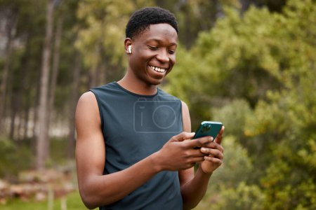 Photo for Phone, earphones and a man outdoor for fitness and listening to music. Happy runner, athlete or african sports person in nature to start exercise, workout or training and streaming radio online. - Royalty Free Image