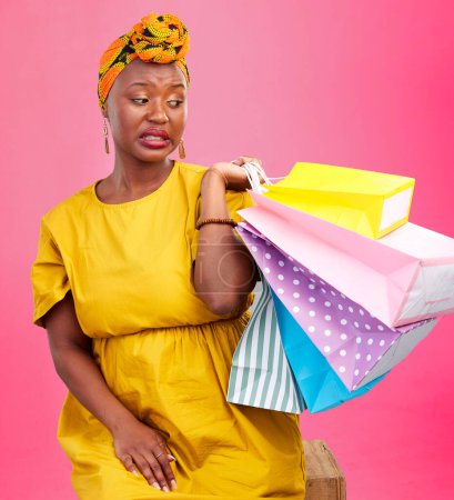 Photo for Studio bag, shopping problem or black woman with bad shop product, boutique crisis or shopaholic. Facial expression, mistake or African customer disappointed with retail present on pink background. - Royalty Free Image