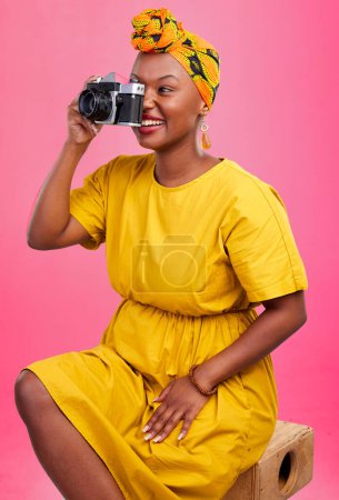 Photo for Camera, studio and happy black woman shooting photo, picture or photography of creative fashion design. Creativity photoshoot, talent artist and African production photographer on pink background. - Royalty Free Image