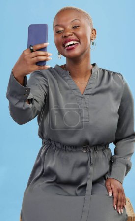 Téléchargez les photos : Heureuse, selfie et femme noire excitée pour l'appel vidéo app mobile isolé en fond bleu studio avec un prix. Connexion, Africaine et heureuse personne ou créateur de contenu en direct sur les médias sociaux. - en image libre de droit