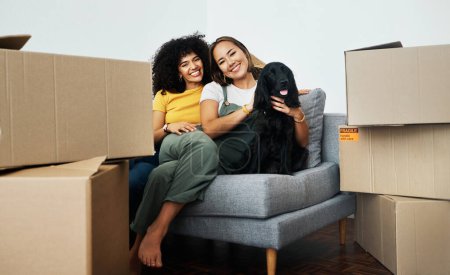 Photo for Real estate, portrait and lesbian couple with a dog on the sofa for moving boxes and a new home. Smile, lgbt and women or people on the living room couch of an apartment with a pet after relocation. - Royalty Free Image