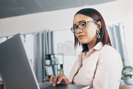 Photo for Laptop, typing and business woman in home living room for startup research, networking and creative freelancer online. Serious designer on computer, reading email and communication for remote work. - Royalty Free Image