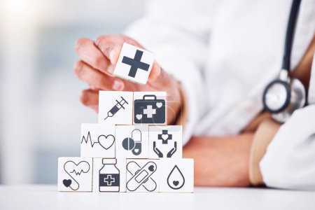 Photo for Hands, medical and a building blocks in a hospital with a doctor closeup for health insurance. Healthcare, icon and symbol with a medicine professional and tower in clinic for cardiology or treatment. - Royalty Free Image
