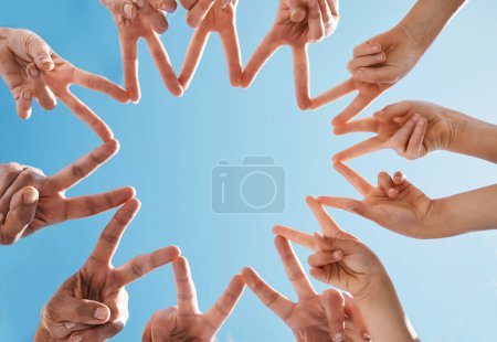 Foto de Manos, grupo y dedos en estrella por la paz, la colaboración y la solidaridad en el cielo azul en ángulo bajo. Familia, forma y conexión a la red, apoyo del equipo y la libertad de los amigos en cooperación para confiar. - Imagen libre de derechos