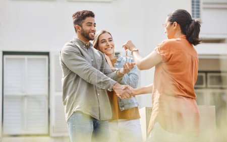 Photo for House key, realtor woman and handshake with couple outdoor as congratulations, thank you or sale. Excited man, partner and shake hands with real estate agent for new home, mortgage or future property. - Royalty Free Image
