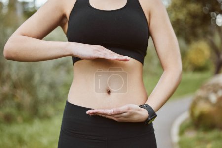 Photo for Woman, hands and stomach in nature for lose weight, tai chi or spiritual wellness in outdoor exercise. Closeup of female person and abdomen for reiki, aura or balance in body care, fitness or park. - Royalty Free Image