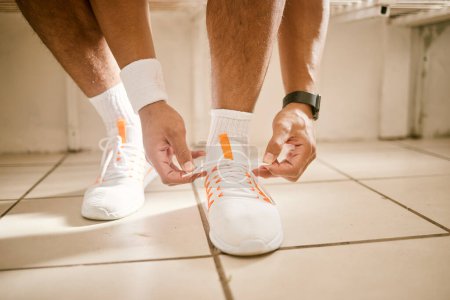 Photo for Locker room, fitness and person tie shoes for training, exercise and workout for practice or match. Sports, gym and closeup of athlete tying laces for performance, wellness and ready for competition. - Royalty Free Image