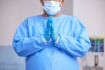 Photo for Doctor, praying and hands with healthcare and surgery, seek guidance from God and worship, hope and operation room. Surgeon person in theatre, prayer and respect with plea, health and ask for help. - Royalty Free Image