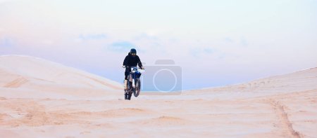 Photo for Rally, desert or athlete driving motorcycle for action, adventure or fitness with performance or adrenaline. Sand, sports or person on motorbike on dunes for training, exercise or race or challenge. - Royalty Free Image