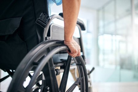 Foto de Mano, rehabilitación y persona en silla de ruedas en un hospital para apoyo médico, transporte y movilidad. Primer plano, ayuda y un paciente con una discapacidad en una silla en una clínica para la recuperación. - Imagen libre de derechos