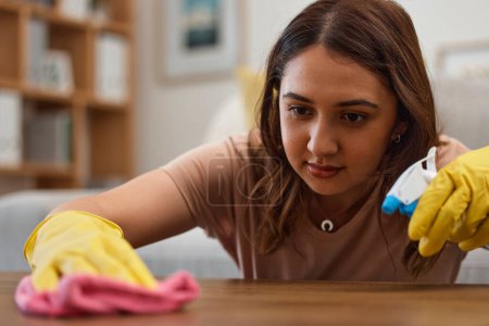 Photo for Woman, cleaning and table with gloves, face and spray at home, detergent and housework in fresh, living room and maintenance. Mexican person, cloth and housekeeping for bacteria, furniture or surface. - Royalty Free Image