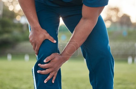 Photo for Sports, injury and person on field with knee pain for accident, emergency and joint ache for muscle sprain. Fitness, healthcare and hands of athlete with strain from exercise, workout and training. - Royalty Free Image
