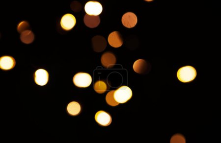 Foto de Oro, luz y maqueta con bokeh sobre fondo oscuro para la celebración de Año Nuevo, Navidad o fuegos artificiales festivos por la noche. Burla, espacio o destello en invierno con magia, brillo o brillo sobre fondo negro. - Imagen libre de derechos