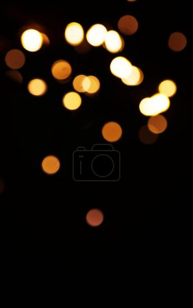 Foto de Oro, luz y maqueta con bokeh sobre fondo oscuro para la celebración de Año Nuevo, Navidad o fuegos artificiales festivos por la noche. Burla, espacio o destello en invierno con magia, brillo o brillo sobre fondo negro. - Imagen libre de derechos