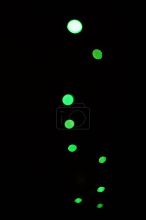 Photo for Green light, bokeh and glow on dark background isolated on a mockup space. Blur, black backdrop and defocused shine, sparkle or glitter at night for Christmas, holiday or party with magic color dots. - Royalty Free Image