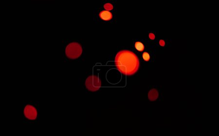 Téléchargez les photos : Rouge, bokeh et lumière dans un studio avec un fond sombre pour la célébration, l'événement ou la fête. Maquette, scintillement et couleur pour lueur, magie ou brillance pour une décoration festive sur fond noir avec maquette - en image libre de droit