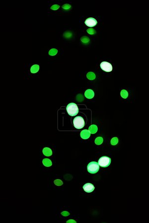 Foto de Luz verde, bokeh y resplandor sobre fondo oscuro aislado en un espacio de maqueta. Desenfoque, fondo negro y brillo desenfocado, brillo o purpurina en la noche para Navidad, vacaciones o fiesta con puntos de color mágicos. - Imagen libre de derechos