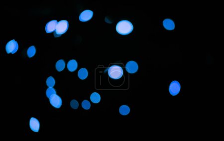 Foto de Azul, confeti y bokeh en un estudio con fondo oscuro para celebración, evento o fiesta. Luces, purpurina y destellos de color para la magia, brillo o resplandor para festivo por telón de fondo negro con maqueta - Imagen libre de derechos