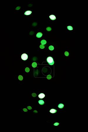 Photo for Green light, bokeh and glow on dark background isolated on a mockup space. Blur, black backdrop and defocused shine, sparkle or glitter at night for Christmas, holiday or party with magic color dots. - Royalty Free Image