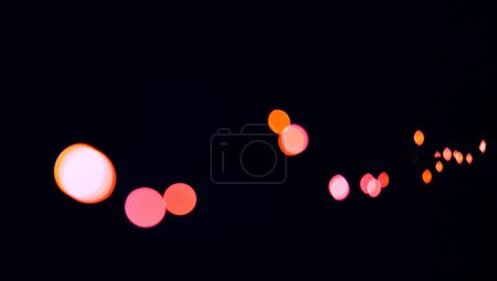 Foto de Bokeh, puntos de color rojo y fondo negro con patrón, textura y luces en maqueta con estética cósmica. Iluminación nocturna, partículas de brillo y brillo en el fondo de pantalla oscuro con espacio, brillo y destello - Imagen libre de derechos