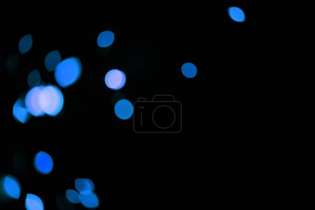 Foto de Bokeh, lunares azules y maqueta sobre fondo negro con patrón, textura y luces con estética cósmica. Iluminación nocturna, partículas de brillo y brillo en el fondo de pantalla oscuro con espacio, brillo de color y destello - Imagen libre de derechos