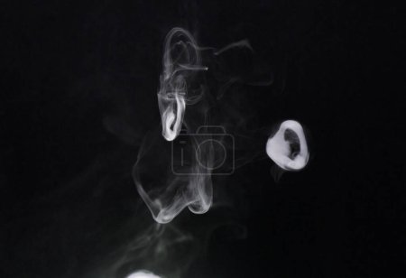 Téléchargez les photos : Fumée, brouillard et bouffée d'air sur fond sombre, vague de vapeur avec nuage de gaz et de fantaisie dans un studio. Texture, vapeur ou vaporisateur avec mystère, encens ou brouillard, glace sèche avec effets spéciaux et smog mouvant. - en image libre de droit