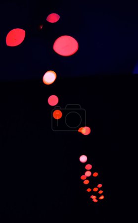 Téléchargez les photos : Bokeh, lampes rouges sur fond noir avec motif, texture et maquettes de points avec esthétique cosmique. Éclairage nocturne, particules scintillantes et lueur sur papier peint sombre avec espace, éclat de couleur et éclat - en image libre de droit