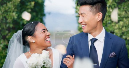 Photo for Couple, flower confetti and wedding event with walk, outdoor or happy laugh in nature. Woman, Asian man and excited for marriage, floral bouquet and love with care in park, party or together in aisle. - Royalty Free Image
