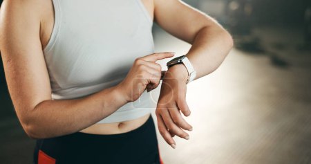 Photo for Smart watch, hands and woman in gym for fitness, exercise results and workout performance. Stopwatch, closeup and check information, timer and monitor healthy training progress, clock and sports gear. - Royalty Free Image
